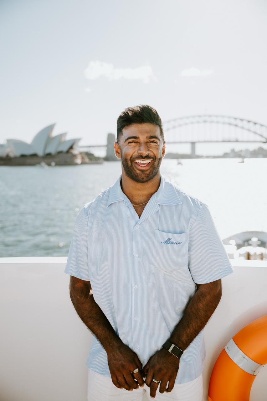 Dr Vinay Patel on Sydney Harbour, Opera House and Harbour Bridge behind him.